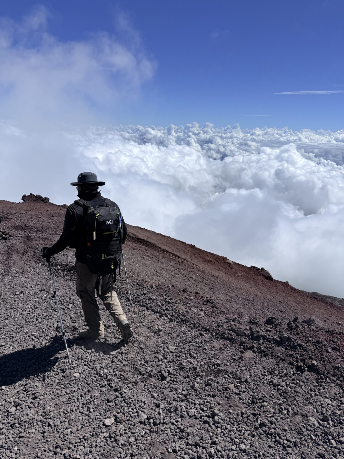 富士山の雲海を眺めながら歩く登山者
