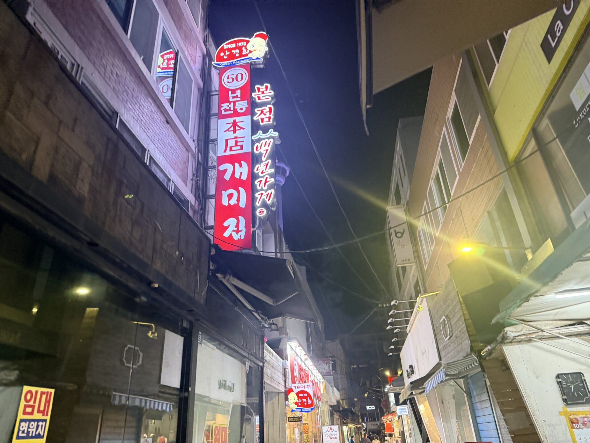 50年伝統と本店の表記がある路地沿いのケミチプの看板